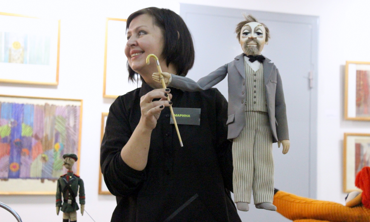Марина Антипина помогает Елене Николаевой демонстрировать кукол. У неё в руках — беллетрист Тригорин.